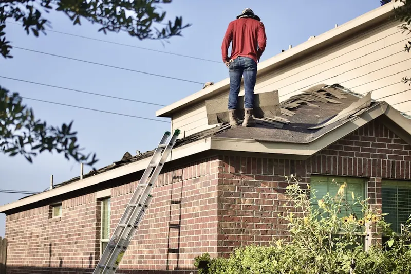 Professional roofer working on a residential roof in West New York